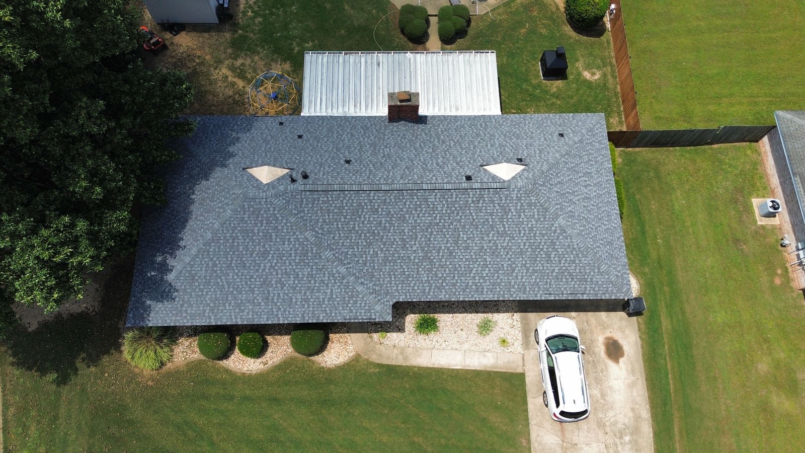 Aerial top-down view of a completed gray architectural shingle roof replacement in Alabama